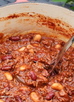 a pot filled with chili and beans on top of a table