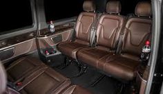 the interior of a vehicle with brown leather seats and black floor mats, including two soda bottles