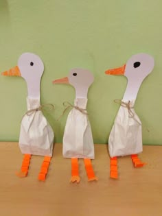 three ducks made out of paper bags on a table