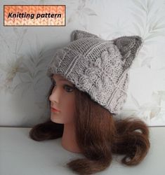 a mannequin head wearing a knitted hat with cat ears on it's side