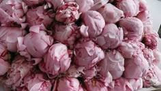 a large pile of pink flowers sitting on top of a table