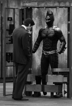 two men dressed as batman standing next to each other