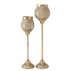 two gold candlesticks sitting next to each other