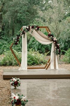 an outdoor ceremony setup with flowers and greenery