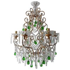 an ornate chandelier with green and clear glass beads hanging from it's center