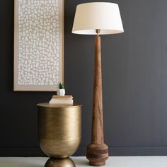 a lamp sitting on top of a table next to a vase