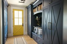 an entryway with blue cabinets and yellow door