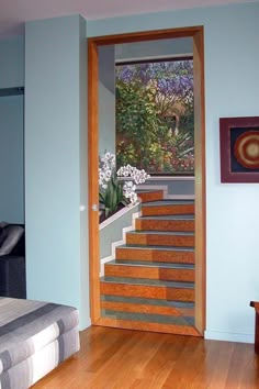 an open door leading to a bedroom with wood flooring and blue walls in the background