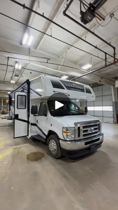 an rv parked in a garage with the door open to show it's interior