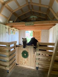 two horses standing on top of wooden stalls