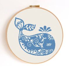 a blue whale with leaves on it's tail is shown in a cross stitch pattern