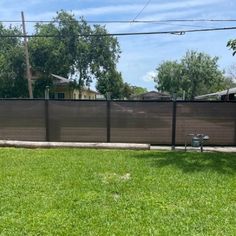 a fenced in yard with green grass and trees