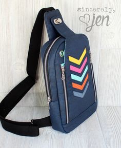 a blue bag with multicolored arrows on the front and black strap around it