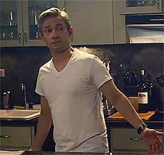 a man standing in a kitchen next to a counter