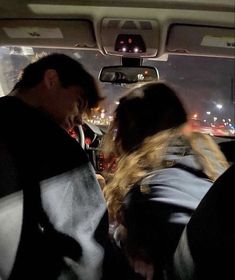 two people sitting in the back seat of a car with their backs to each other