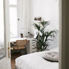 a bedroom with white walls and wooden floors