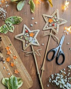 two star shaped cookies sitting on top of a cutting board next to scissors and flowers