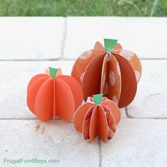 three paper pumpkins sitting on the ground