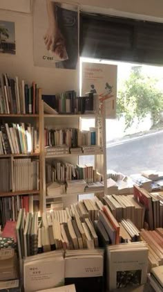 a room filled with lots of books next to a window