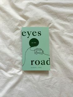 the book eyes on the road is laying on a white sheet with an image of a car