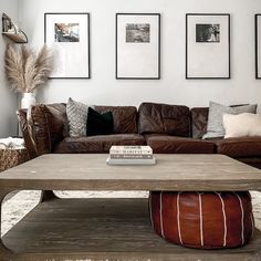 a living room filled with furniture and pictures hanging on the wall above it's coffee table