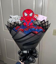 a person holding a bouquet with spiderman on it