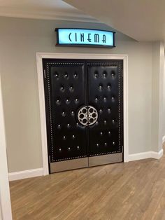 an empty room with two doors and a sign that says cinema