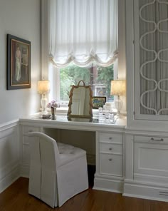 a white desk and chair in front of a window