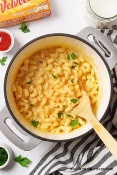 a pot filled with macaroni and cheese on top of a table