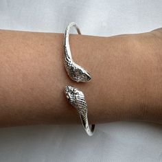 Crafted from solid .925 sterling silver, this Snake Bangle embodies transformation and eternal elegance— honored symbols. A perfect symbol of rebirth and divine authority, it offers a meaningful gift or a special touch to your collection. Ideal for the modern woman who carries the essence of strength and renewal. Material & Features: • Solid .925 Sterling Silver Bangle Bracelets• Bangle thickness: approximately 2.5 mm• Standard size: 8", weight approximately 15 grams for the piece• Available siz Symbolic Adjustable Promise Jewelry, Sterling Silver White Gold Bracelet For Promise, Sterling Silver White Gold Promise Bracelet, Symbolic Sterling Silver Promise Jewelry, Silver Flexible Round Bangle, Classic Flexible Sterling Silver Jewelry, Flexible Classic Sterling Silver Jewelry, Silver Sterling Silver Bracelets For Promise, Adjustable Silver Cuff Bracelet For Promise