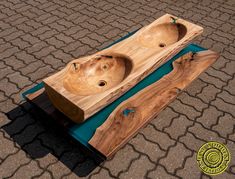 two wooden bowls sitting on top of a blue tableclothed surface with an oval hole in the middle