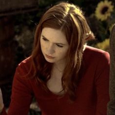 a woman sitting at a table looking down