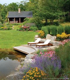 a wooden dock sitting in the middle of a lush green field next to a pond