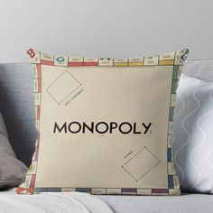 a monopoly pillow sitting on top of a couch with the word monopoly printed on it