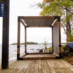 a gazebo on a wooden deck next to the water