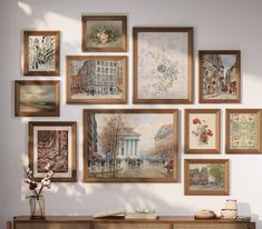 a wall with many framed pictures on it