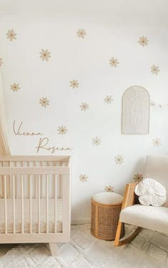 a baby's room with a crib, rocking chair and wall decals