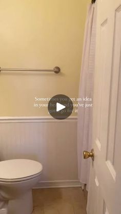 a white toilet sitting in a bathroom next to a shower curtain with the door open