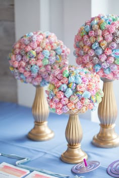 two vases filled with candy sitting on top of a blue tablecloth covered table