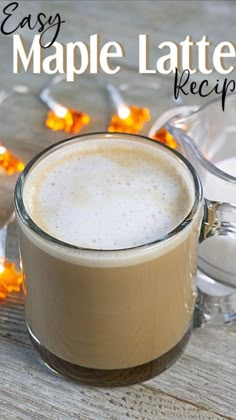 an easy maple latte recipe in a glass mug on a wooden table surrounded by christmas lights