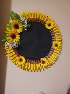 a mirror made out of pops sticks and sunflowers