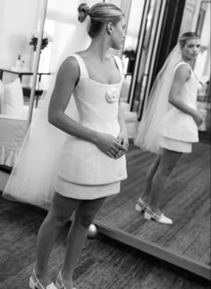 a woman standing in front of a mirror