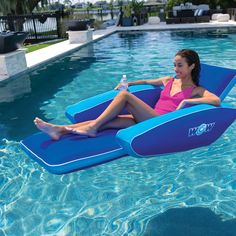 a woman is sitting on an inflatable chair by the pool