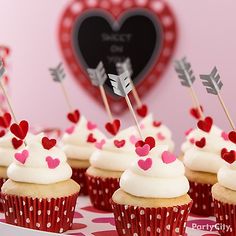 cupcakes with white frosting and red hearts on them