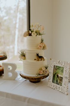 a three tiered cake sitting on top of a table next to a framed photo