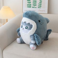 a blue and white stuffed animal sitting on top of a couch