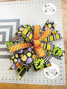 a close up of a ribbon on a cutting board with scissors and buttons in the background