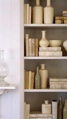 the shelves are filled with books and vases