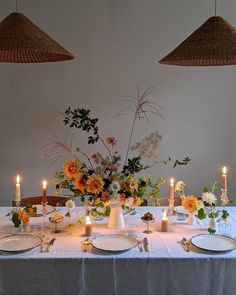 the table is set with flowers and candles for dinner guests to sit down at it