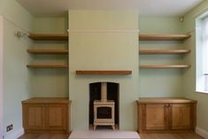 an empty room with shelves and a fireplace